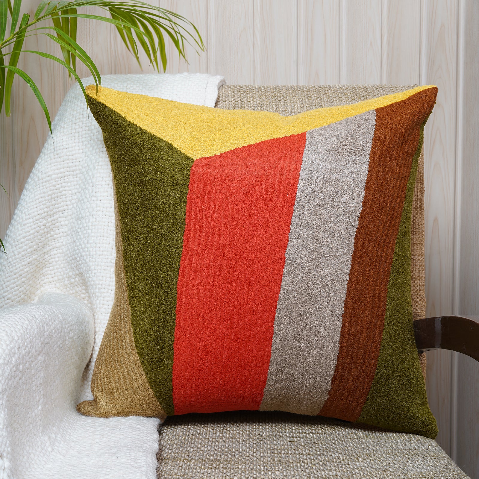 Square embroidered cushion in rich earthy tones with bold vertical color blocks, inspired by Bauhaus design